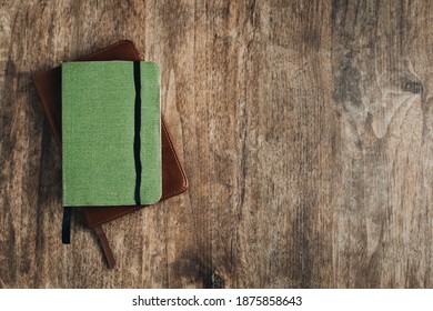 Small Bible And A Small Notebook On A Wooden Texture. Bible Study Desk