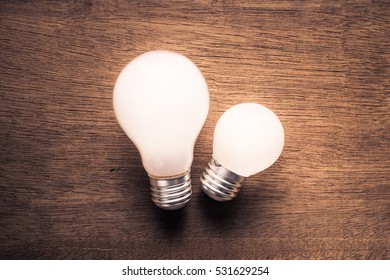 Small And Big Light Bulb, Small And Medium Sized Business, Coaching, Training, Or Other Comparison Concept