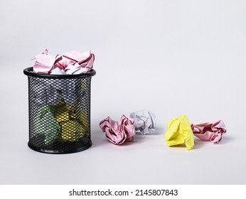 A small black basket made of round steel. Used to put garbage, documents that are not work and have been crushed so much that it overflows outside. In the white background there is copy space.