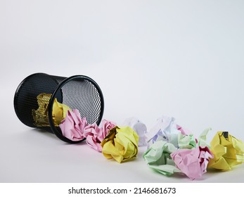 A small black basket made of round iron fell down. It is used to put the trash, documents that are not working and are overflowing to the outside. In the white background there is a copy space.