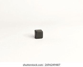 Small black cube object on white background, minimalistic concept of geometric shape and modern simplicity.