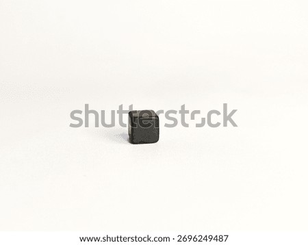 Small black cube object on white background, minimalistic concept of geometric shape and modern simplicity.