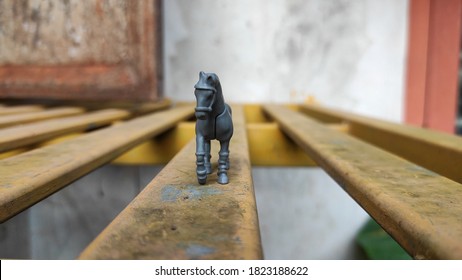 A Small Black Horse On A Iron Rod