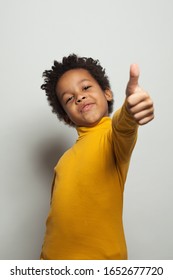 Small Black Kid Boy Holding Thumb Up And Smiling On White Background