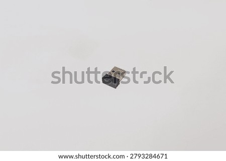 Small black and silver USB wireless dongle receiver for computer mouse on white background
