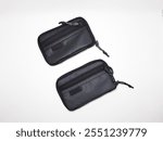 Small black zip pouch and grey zip pouch lying on white background