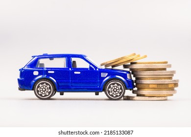 A Small Blue Car Hit The Stack Of Money Coins At The Front, Car Accident And Insurance, Compensation, Car Finance Problem, Car Maintenance, Or Penalty Offense