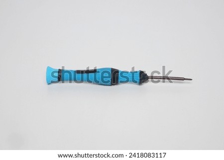 A small blue cell phone screwdriver with flat lay made of plastic on a white background                        