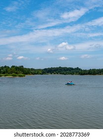 A Small Blue Paddle Boat Moves Across Freeman Lake In Elizabethtown, KY On A Beautiful Sunny Summer Day.