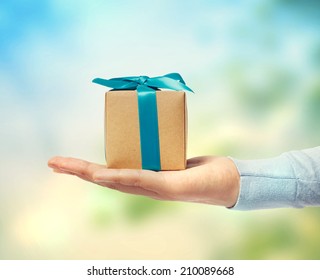 Small Blue Ribbon Gift Box On A Hand