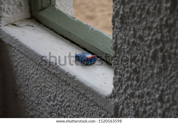 A\
small blue toy car, left behind in an old\
building