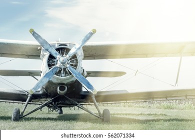 Small Blue And White Plane On A Background Of Green Grass And Blue Sky. Toned.