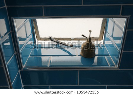 Small blue window with a brass ornament 