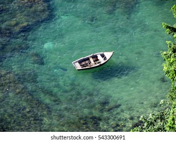 Small Boat Anchored At Bay Of All Saints With Clear Emerald Waters In Salvador, Bahia - Brazil.                            