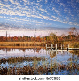 A Small Boat And Fishing Pier Under Beautiful Morning Skies On Lake Sixteen During Autumn, Oakland County Michigan. USA