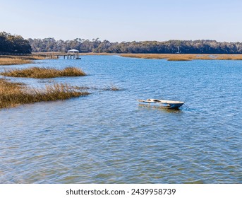 Small Boat Floating on Skull Creek at The Pope Squire Community Park, Hilton Head, South Carolina, USA