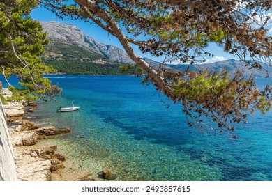 Small boat moored by rocky beach in picturesque old Korcula town on Korcula island, Croatia - Powered by Shutterstock