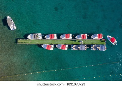 Small Boat Towing A Floating Light Dock With Small Boats, Aerial View.