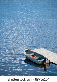 Small Boat Waits At A Wooden Dock