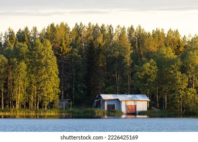 A small boathouse on the bank of a lake in summery Finland	