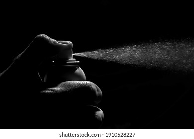 Small Bottle Of Anti Bacterial Spray Being Pressed By A Worn Hand In Dramatic Black And White Lighting. Clean Disinfectant Aerosol Spray