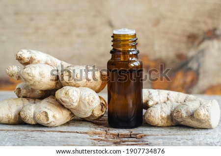 Small bottle with essential ginger oil (extract, tincture, infusion, perfume). Aromatherapy, spa and herbal medicine ingredients. Old wooden background. Copy space 
 [[stock_photo]] © 
