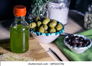A small bottle with extra virgin olive oil from Trapani and two Sicilian bowls with white and black olives