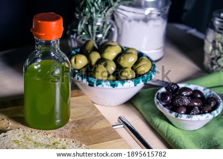 A small bottle with extra virgin olive oil from Trapani and two Sicilian bowls with white and black olives