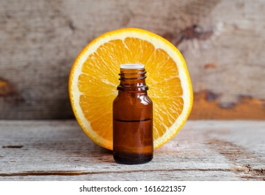 Small Bottle With Sweet Orange Essential Oil (extract, Tincture, Infusion, Perfume). Aromatherapy, Spa And Herbal Medicine Ingredients. Old Wooden Background. Copy Space