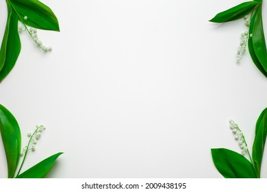Small bouquets of lilly of the valley in the corners with empty space. Flat lay with white background.  - Shutterstock ID 2009438195