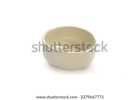 A small bowl of light cream color dipping sauce sits on a white background.	