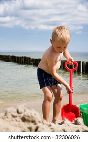 Small boy digging in sand on beach