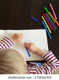 Small boy draws at the table. Top view, felt-tip pens of different colors are on the table - Shutterstock ID 1734163310