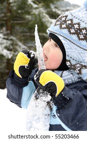 Small Boy Eat Icicle In Winter On Mountains