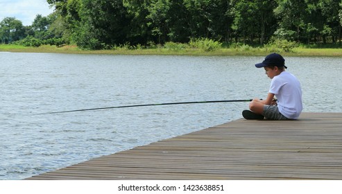 Small Boy Fishing Alone At Lake