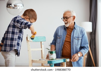 Small boy and his grandfather repairing furniture and having fun while painting chair in blue color.  - Powered by Shutterstock