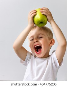 small boy holds a big green apple, healthy food and vitamins, smiling, white background, soft focus