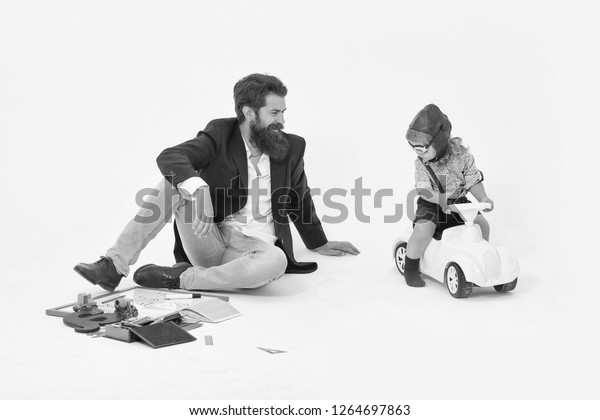 small boy kid driver or pilot sitting on\
plastic toy cat in stylish shirt with bearded man father with beard\
near school appliances of blackboard letter pen and paper isolated\
on white background.