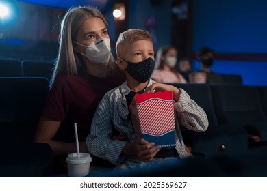 Small Boy With Mother Eating Popcorn In The Cinema, Watching Movies And Coronavirus Concept.