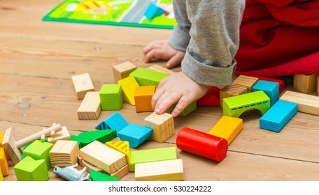 Small Boy Playing With Wooden Blocks On Floor. Baby Toy And Child.