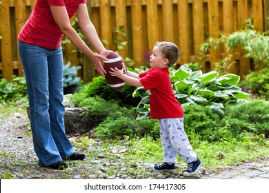 A Small Boy Receives A Hand Off From His Mommy In A Game Of Backyard Football. 