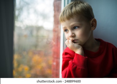 small boy sitting near window and thinking about something - Powered by Shutterstock