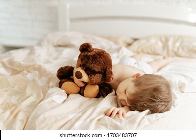 Small Boy Sleeping in Bed and Hugging Teddy Bear. Relaxation Cute Preschooler Child with Toy Sleep. Tired and Tranquil Caucasian Kid, White Brick Wall on Blurred Background. Sweet Dreams