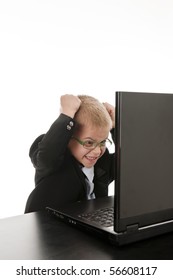 A Small Boy In The Studio, Dressed Up In A Suit And Pretending To Be A Businessman Working On A Computer, Isolated On White.