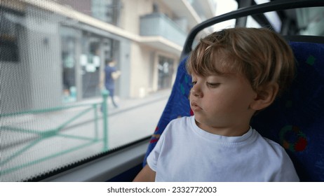 Small boy traveling by bus passenger kid travs by public transportation looking out window