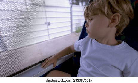 Small boy traveling by bus passenger kid travs by public transportation looking out window