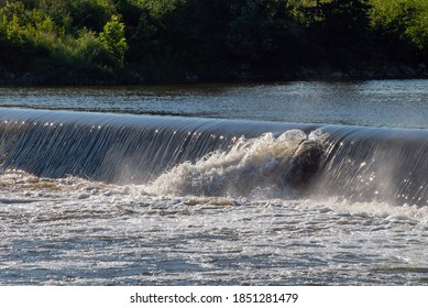 A small breach in the dam at a Kansas river allows water to gush through and make splashes. Bokeh. - Shutterstock ID 1851281479