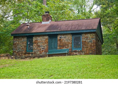 A Small Brick Cabin Sits At The Top Of A Hill