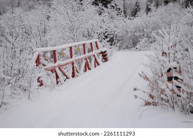 Small bridge with red railing in winter in Northern Ontario