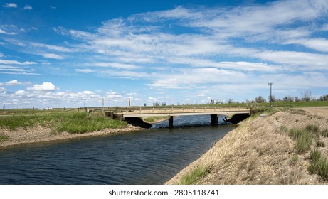 A small bridge spanning a ditch, often used as a road in rural areas.